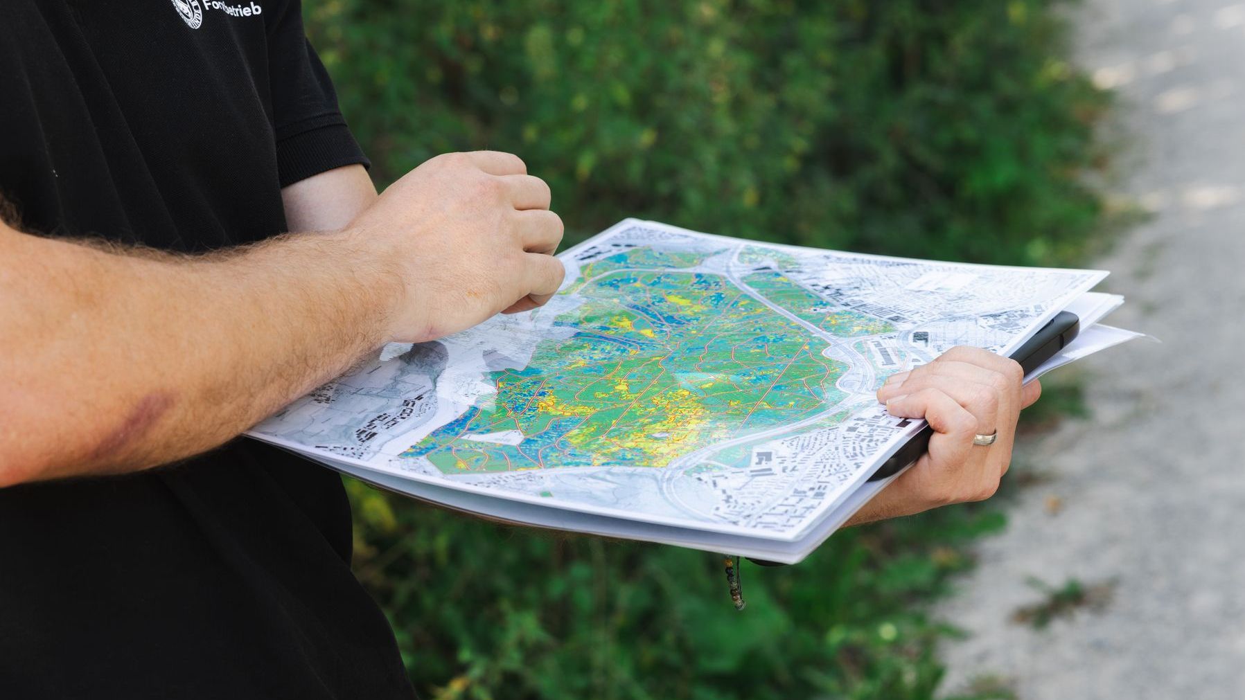 Zwei Hände, welche eine Karte des Waldes halten
