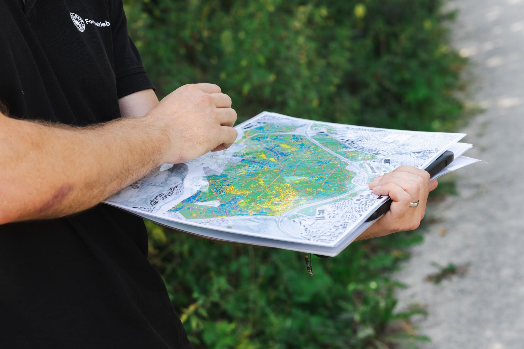 Zwei Hände, welche eine Karte des Waldes halten